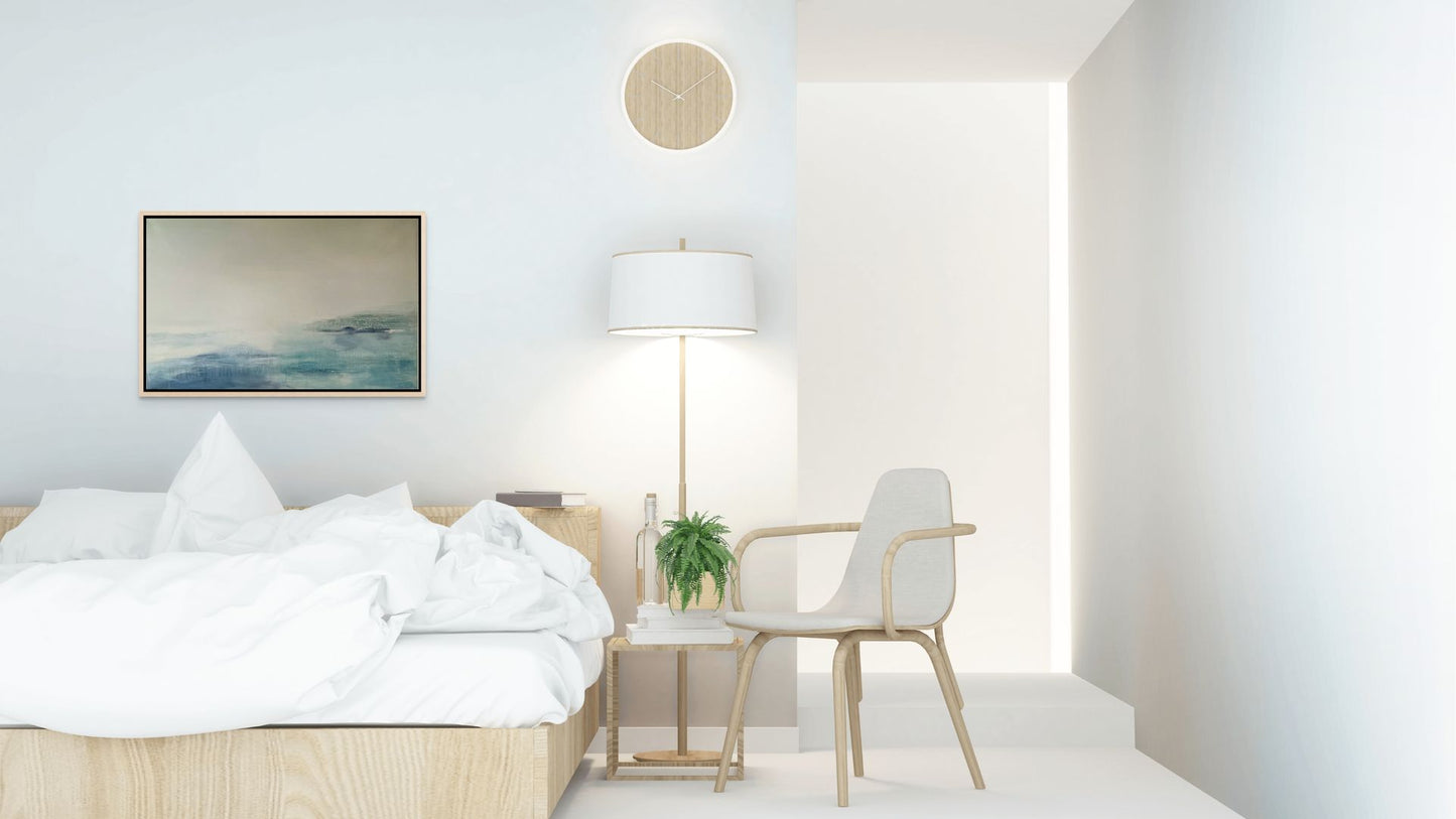 Modern bedroom with a bed, chair, lamp, and blue abstract minimal seascape artwork on a white wall.