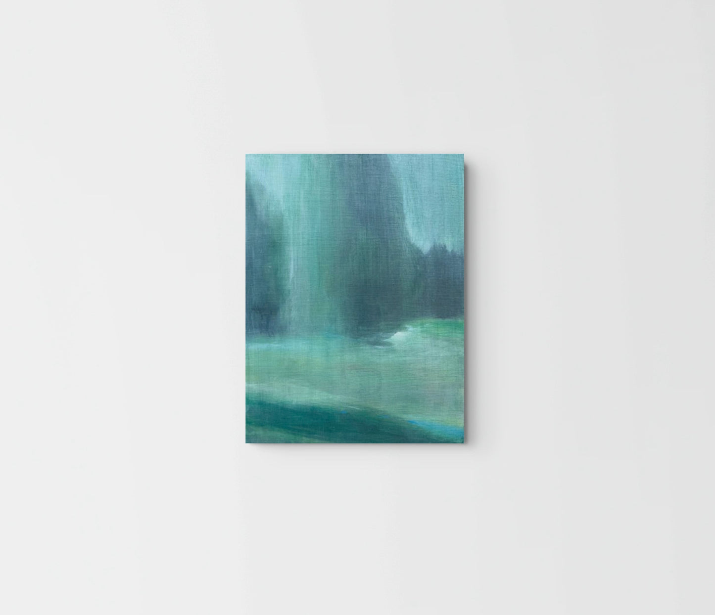 A vertical canvas print featuring an abstract landscape painting in shades of teal, green, and blue, displayed against a clean white wall.